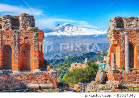 Ruins of ancient Greek theater in Taormina and Etna volcano in the backgroun Ruins of ancient Greek theater in Taormina and Etna volcano in the backgroun 98514348