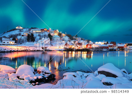 Dramatic evening cityscape of Reine town with Northern Lights. Dramatic evening cityscape of Reine town with Northern Lights. 98514349