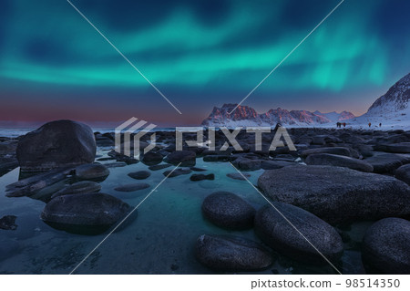 Amazing winter scenery on Uttakleiv beach at night with Northern lights. Amazing winter scenery on Uttakleiv beach at night with Northern lights. 98514350