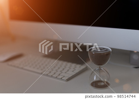 Hourglass on laptop keyboard. Time management concept Hourglass on laptop keyboard. Time management concept 98514744
