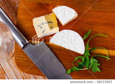 Slices of soft blue cheese on cutting board 98515005