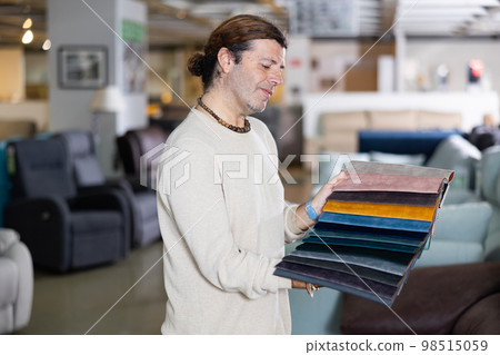 Middle-aged man chooses upholstery color of furniture Middle-aged man chooses upholstery color of furniture 98515059