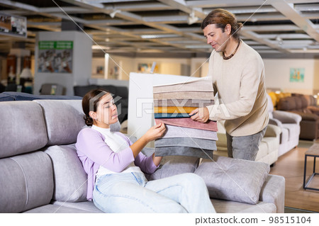 couple discussing collection of fabrics for furniture in apartment couple discussing collection of fabrics for furniture in apartment 98515104