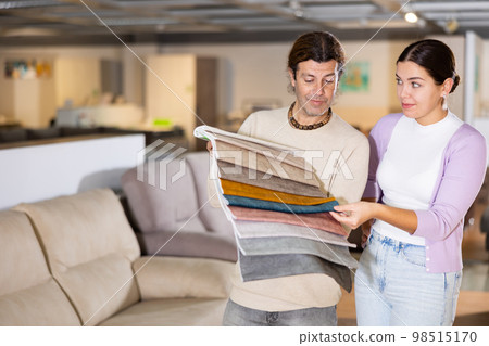Happy man and woman choosing wooden furniture in furniture showroom Happy man and woman choosing wooden furniture in furniture showroom 98515170