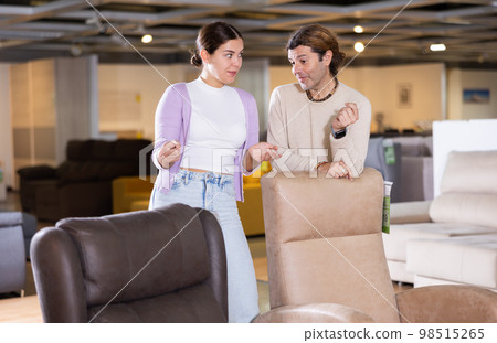 couple chooses comfortable armchair in furniture store couple chooses comfortable armchair in furniture store 98515265