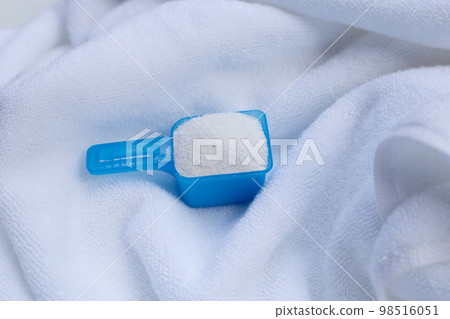 Detergent powder in measuring spoon on towel before washing. Laundry concept. Detergent powder in measuring spoon on towel before washing. Laundry concept. 98516051