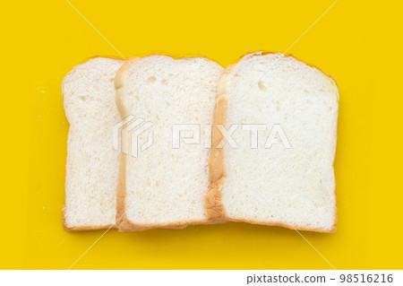 Stack of sliced bread on yellow background. Stack of sliced bread on yellow background. 98516216