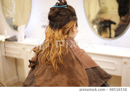 Woman holding her hair with a hair clip Woman holding her hair with a hair clip 98516538