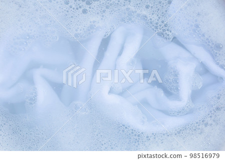 Top view of towel soak in powder detergent water dissolution. Laundry concept Top view of towel soak in powder detergent water dissolution. Laundry concept 98516979