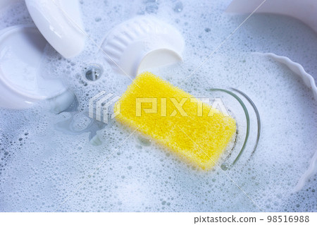 Dishes and bowls in water and bubbles of dishwashing liquid Dishes and bowls in water and bubbles of dishwashing liquid 98516988