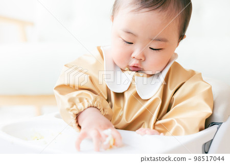 A baby in the kamikami period who grabs and eats baby food A baby in the kamikami period who grabs and eats baby food 98517044