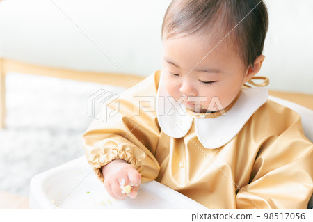 A baby in the kamikami period who grabs and eats baby food A baby in the kamikami period who grabs and eats baby food 98517056