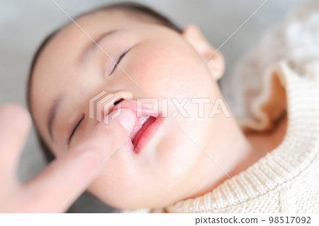 Baby whose upper front teeth have begun to grow Hello teeth 9 months old 98517092