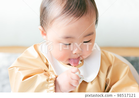 A baby in the baby's term who grabs and eats baby food. 98517121