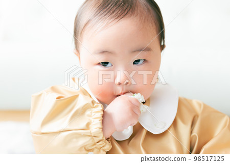 A baby in the kamikami period who grabs and eats baby food 98517125