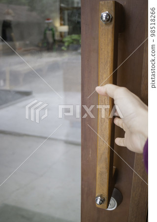 Woman opens the door holding the handle 98518266