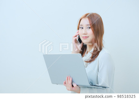 Business woman with a PC on her left hand and a smartphone on her right hand Business woman with a PC on her left hand and a smartphone on her right hand 98518325