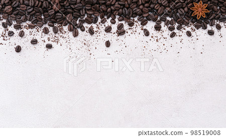 Dark roasted coffee beans setup on white concrete background with copy space. 98519008