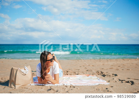 Young happy woman on the beach enjoy her summer vacation Young happy woman on the beach enjoy her summer vacation 98519080