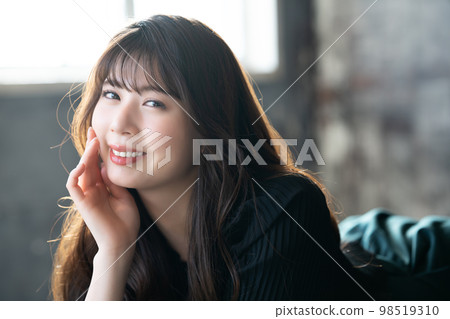 Fashionable young woman lying down and relaxing Fashionable young woman lying down and relaxing 98519310