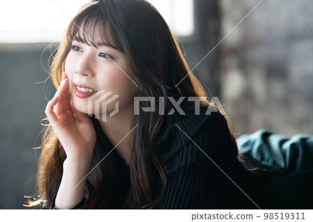 Fashionable young woman lying down and relaxing Fashionable young woman lying down and relaxing 98519311