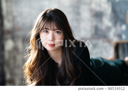 Fashionable young woman lying down and relaxing Fashionable young woman lying down and relaxing 98519312