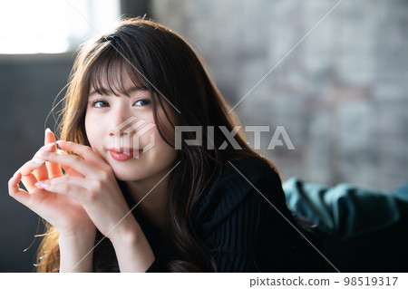 Fashionable young woman lying down and relaxing Fashionable young woman lying down and relaxing 98519317