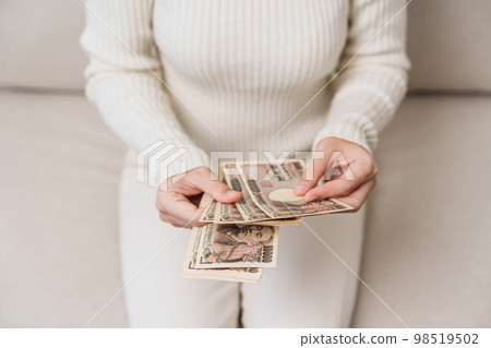 Woman hand holding Japanese Yen banknote stack. Thousand Yen money. Japan cash, Tax, Recession Economy, Inflation, Investment, finance and shopping payment concepts 98519502