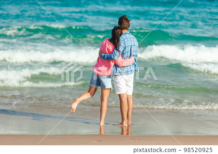 Young couple in love on the beach summer vacation. Happy man and woman enjoy time together Young couple in love on the beach summer vacation. Happy man and woman enjoy time together 98520925