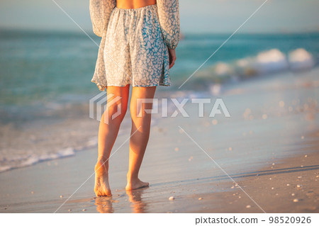 Female legs on the beach closeup. Woman in dress walking on the beach 98520926