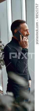 Man standing and talking on the phone 98521757