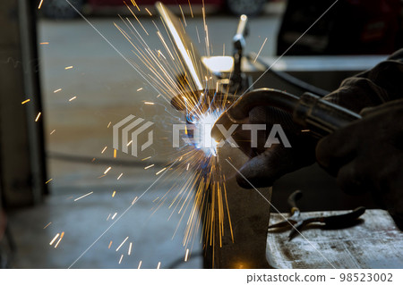 Using semi-automatic argon gas shielded welding machine worker is welding metal Using semi-automatic argon gas shielded welding machine worker is welding metal 98523002