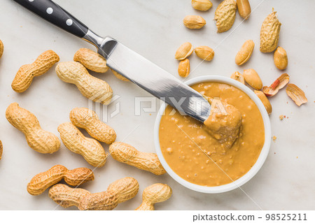 Peanut butter in bowl on kitchen table. Top view. Peanut butter in bowl on kitchen table. Top view. 98525211