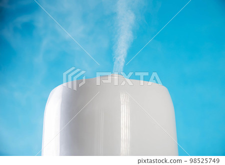 Modern air humidifier on a blue background. Humidification in the room, close-up 98525749