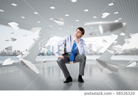 Young businessman sitting on an office chair Young businessman sitting on an office chair 98526320