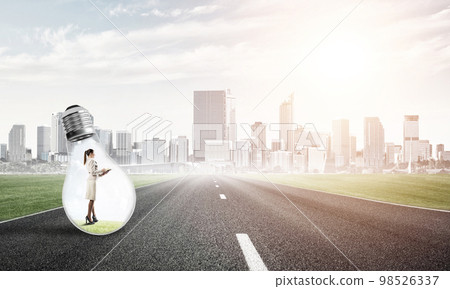 Businesswoman inside light bulb Businesswoman inside light bulb 98526337