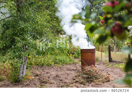Burning dry grass and garbage in the country in the fall in an iron barrel. Penalty and fire hazard if weed is burned incorrectly. A lot of smoke Burning dry grass and garbage in the country in the fall in an iron barrel. Penalty and fire hazard if weed is burned incorrectly. A lot of smoke 98526724