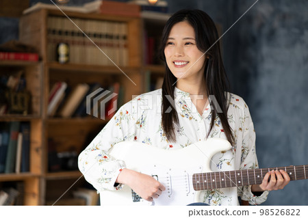 A young lady playing the guitar A young lady playing the guitar 98526822