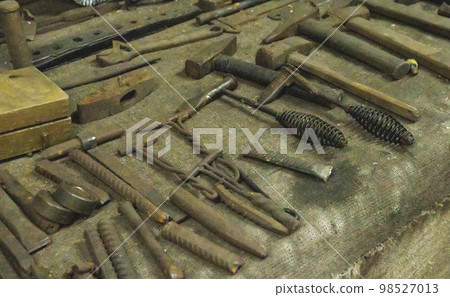 Lots of metal tools to work in the forge. Background, industry. Lots of metal tools to work in the forge. Background, industry. 98527013