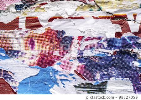 Torn paper collage background on an old poster on a street wall. Texture and surface of torn paper. Torn paper collage background on an old poster on a street wall. Texture and surface of torn paper. 98527059