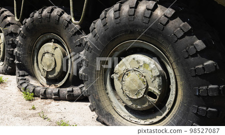 Wheels of armored personnel carriers pierced by bullets during a military battle. Military conflict and weapons. Equipment damage. Wheels of armored personnel carriers pierced by bullets during a military battle. Military conflict and weapons. Equipment damage. 98527087
