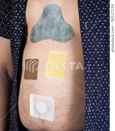 Many different medical plasters are glued on the human body. Anti-inflammatory, fat burning and anti-smoking. The concept of treatment with patches in medicine. 98527239