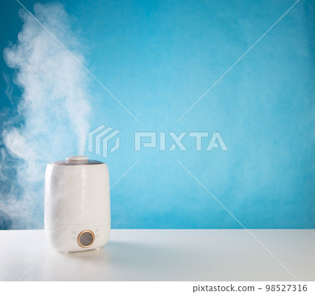 Modern air freshener on a table on a blue background. Copy space for text, aromatherapy 98527316