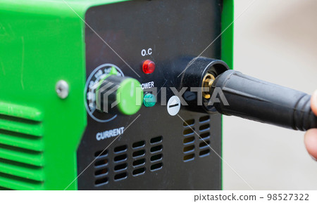 Adjusting the current strength on a modern welding machine. Welding arc. Close-up 98527322