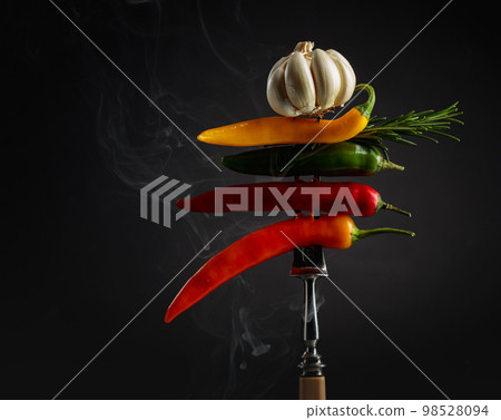 Red hot chili peppers with garlic and rosemary on black background. Red hot chili peppers with garlic and rosemary on black background. 98528094