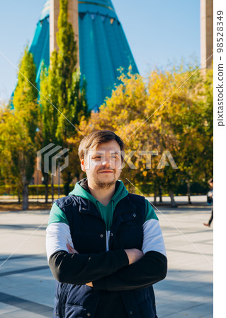 Young male man on Muslim Mosque and yellow trees. Lifestyle portrait of european white caucasian unshaven beard adult man. Religion and travel concept, vertical photo. Young male man on Muslim Mosque and yellow trees. Lifestyle portrait of european white caucasian unshaven beard adult man. Religion and travel concept, vertical photo. 98528349