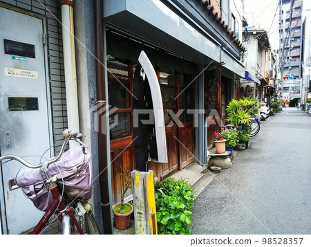 A back alley in downtown with a unique kitchen knife sign in front. Intricately tangled wires overhead A back alley in downtown with a unique kitchen knife sign in front. Intricately tangled wires overhead 98528357