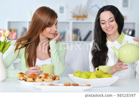 two female friends drinking tea 98528397