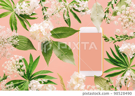 Smartphone mockup among Assorted floral and jungle tree green leaves and white flowers on peach pink. Natural friendly plants care or gardening planting mobile app technology Smartphone mockup among Assorted floral and jungle tree green leaves and white flowers on peach pink. Natural friendly plants care or gardening planting mobile app technology 98528490
