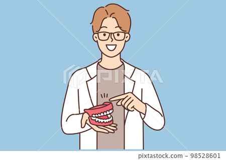 The dentist shows the model of the jaw The dentist shows the model of the jaw 98528601